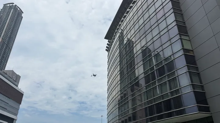 A Swift Cruise drone surveying a curtain-wall facade in Hong Kong