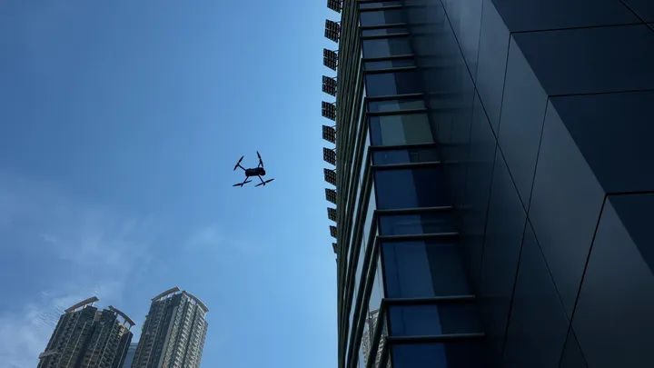 A drone flying beside a curtain wall façade in Hong Kong