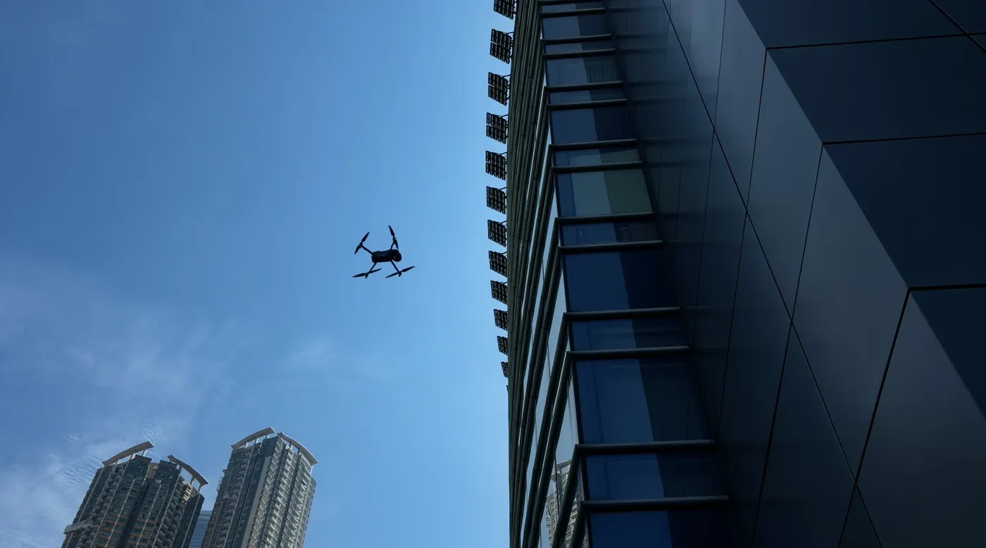 A drone flying beside a curtain wall façade in Hong Kong