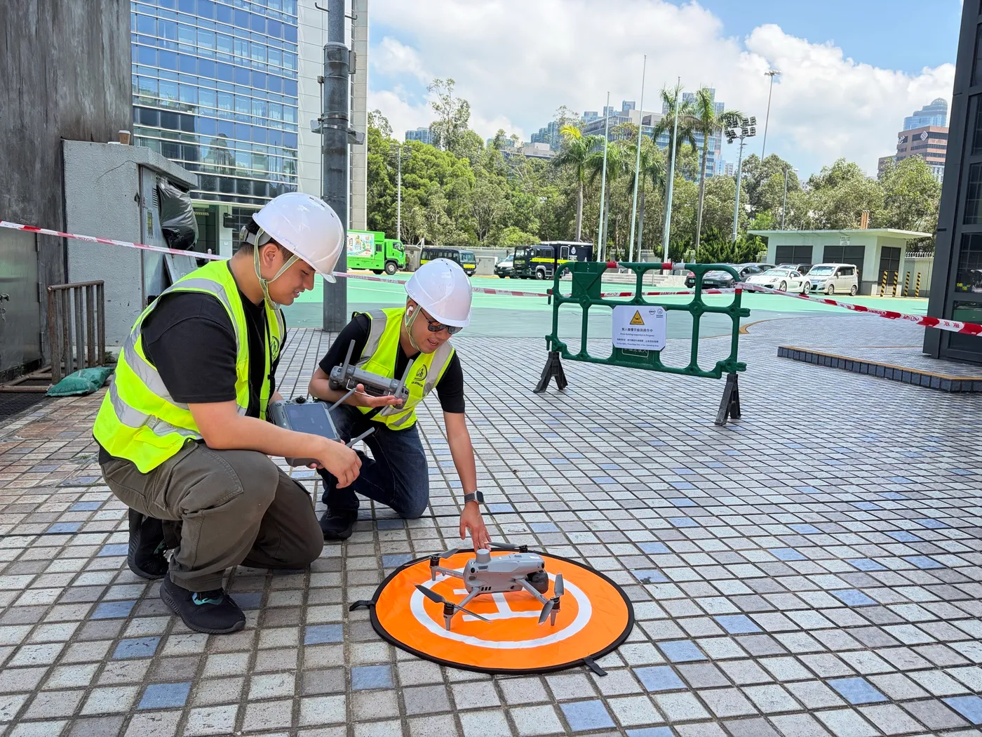 Two Swift Cruise pilots in helmets and hi-vis vests preparing a drone on a landing pad